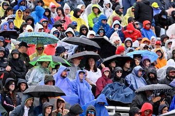 Los espectadores se resguardan de la lluvia con paraguas y chubasqueros, en el circuito de Gilles Villeneuve, momentos antes de comenzar la carrera.