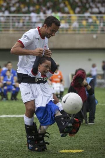 El futbolista brasileño Nene ayuda al niño Rikellmy durante un evento con niños discapacitados, en Praia Grande (Brasil). El campo de fútbol del Instituto Neymar Jr fue el escenario de la final del campeonato "Bota do Mundo", una cita apadrinada por el jugador del Barcelona.