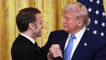 U.S. President Donald Trump and French President Emmanuel Macron hold hands on the day of a press conference, at the White House in Washington, D.C., U.S., February 24, 2025. REUTERS/Evelyn Hockstein