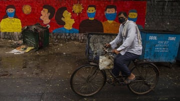 NEW DELHI, INDIA - JULY 17: An Indian cyclist paddles his bicycle in front a mural on July 17, 2020 in New Delhi, India. With the highest single-day surge of 34,956 cases, Indias confirmed Covid-19 infections crossed the 1 million mark as the worlds thi