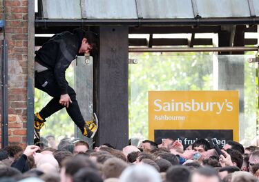 Un hombre se coloca en un hueco para vivir el partido. 