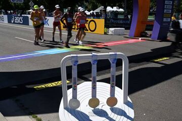 Medals for the men's 20km race walk are displayed as athletes pass during the World Athletics Championships in Eugene, Oregon on July 15, 2022. (Photo by Jim WATSON / AFP) (Photo by JIM WATSON/AFP via Getty Images)