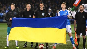 PETERBOROUGH, ENGLAND - MARCH 01: Oleksandr Zinchenko of Manchester City, Referee Andy Madley and Frankie Kent of Peterborough United hold a Ukrainian flag to indicate peace and sympathy with Ukraine prior to the Emirates FA Cup Fifth Round match between