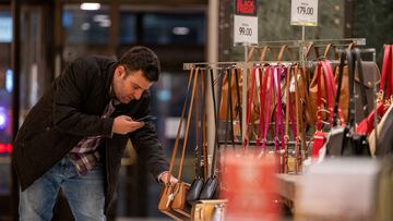 FILE PHOTO: A shopper uses a phone at Macy's department store during Black Friday shopping in Manhattan in New York City, New York, U.S., November 24, 2023. REUTERS/David Dee Delgado/File Photo
