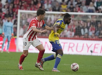 Kouam en el encuentro en El Molinn presionado por Mndez, del Sporting.