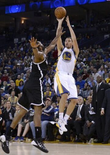 Klay Thompson lanza por encima de Alan Anderson.