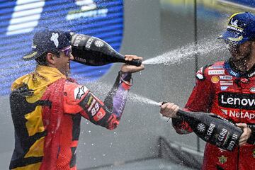 Jorge Martín y el piloto italiano Francesco Bagnaia se echan mutuamente champán en el podio. 