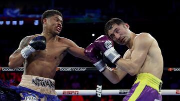 El boxeador estadounidense Shakur Stevenson golpea al japonés Shuichiro Yoshino durante un combate de boxeo.