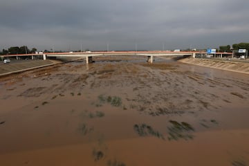 El agua fluye por el nuevo cauce del río Turia con un color fangoso en Valencia, España.