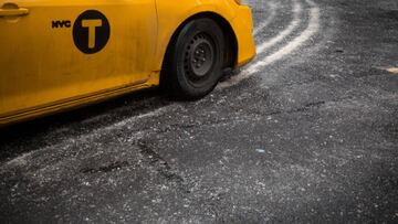 A taxi drives along a salted road following a storm in New York.
