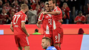 Bayern Munich's English forward #09 Harry Kane (R) celebrate with Bayern Munich's Colombian forward #14 Luis Diaz (2R) and Bayern Munich's Austrian midfielder #27 Konrad Laimer after scoring his team's fourth goal as Leipzig's Hungarian goalkeeper #01 Peter Gulacsi (front bottom) looks on during the German first division Bundesliga football match between FC Bayern Munich and RB Leipzig in Munich, southern Germany, on August 22, 2025. (Photo by Karl-Josef Hildenbrand / AFP) / DFL REGULATIONS PROHIBIT ANY USE OF PHOTOGRAPHS AS IMAGE SEQUENCES AND/OR QUASI-VIDEO