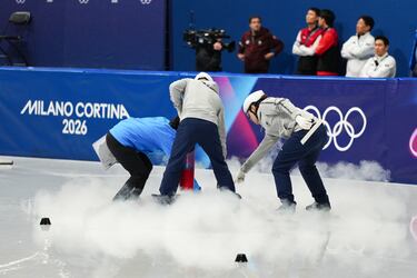 Trabajadores preparando la pista para la prueba de patinaje de velocidad en pista corta.
