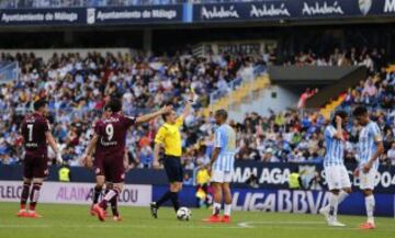 El defensa del Málaga Samuel Sanchez recibe una tarjeta amarilla por agarrar del brazo al delantero del Deportivo Lucas Pérez