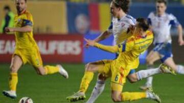 Vlad Chiriches (Ruman&iacute;a) intenta robarle un bal&oacute;n a Joan Edmundsson (Islas Feroe).