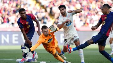 Valladolid's goalkeeper Karl Hein, bottom, fails to save a goal by Barcelona's Raphinha, right, during the Spanish La Liga soccer match between FC Barcelona and Valladolid at the Olympic stadium in Barcelona, Spain, Saturday, Aug. 31, 2024. (AP Photo/Joan Monfort)