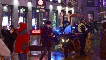 MADRID, 19/12/2020.- Vista del ambiente en la Puerta del Sol en Madrid, en cuyas inmediaciones se han producido controles de acceso para peatones en dirección a la Puerta del Sol para evitar aglomeraciones de público, esta noche en Madrid.- EFE/VÍctor Lerena.
