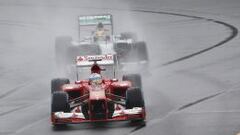 Fernando Alonso pilota su Ferrari delante del Mercedes de Lewis Hamilton en la primera sesi&oacute;n calificatoria del GP de Australia.