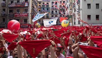 Participants hold red scarves as they celebrate the &#039;Chupinazo&#039; (start rocket) to mark the kickoff at noon sharp of the San Fermin Festival, in front of the Town Hall of Pamplona, northern Spain, on July 6, 2018. / AFP PHOTO / JAIME REINA