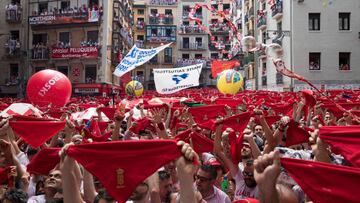 Participants hold red scarves as they celebrate the 'Chupinazo' (start rocket) to mark the kickoff at noon sharp of the San Fermin Festival, in front of the Town Hall of Pamplona, northern Spain, on July 6, 2018. / AFP PHOTO / JAIME REINA