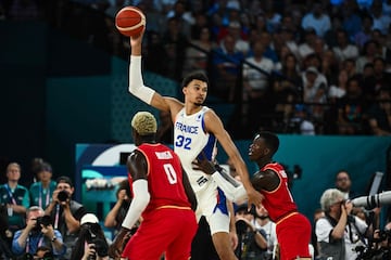 Victor Wembanyama destaca en alto mientras es defendido por el base alemán Dennis Schroder (1,85m) durante la semifinal olímpica disputa entre Francia y Alemania.