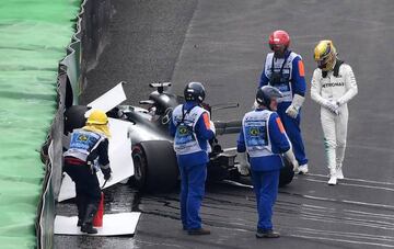 Hamilton looks despondently at his wrecked motor