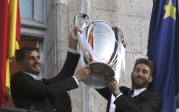 Los capitanes del Real Madrid, Iker Casillas (i) y Sergio Ramos, muestran la copa a los aficionados en el balcón de la sede de la Comunidad de Madrid, durante las celebraciones tras la victoria en la final de la Liga de Campeones disputada ayer en Lisboa.