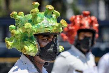 Traffic police personnel wearing coronavirus-themed helmets participate in a campaign to educate the public during a government-imposed nationwide lockdown as a preventive measure against the COVID-19 coronavirus in Bangalore on March 31, 2020. (Photo by 