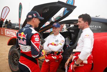 El piloto francés Sebastien Loeb de Bahrain Raid Xtreme y su copiloto beñga Fabian Lurquin charlan con el copiloto francés de Toyota Gazoo Racing Mathiu Baumel.