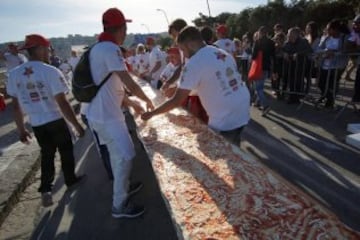 Fotografía facilitada hoy, 19 de mayo de 2016 de una pizza napolitana de dos kilómetros de largo, elaborada para batir el récord del mundo, y colocada a lo largo del paseo marítimo en Nápoles (Italia) ayer. EFE/Ciro Fusco