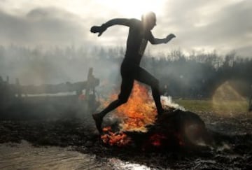 Un participante en el evento anual Tough Guy en Inglaterra, carrera internacional de obstáculos, con agua, fuego y túneles....