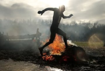 Un participante en el evento anual Tough Guy en Inglaterra, carrera internacional de obstáculos, con agua, fuego y túneles....
