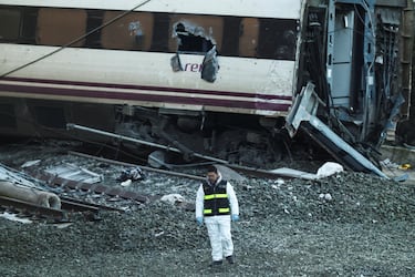 Un miembro de la Guardia Civil española se encuentra cerca de los restos de un tren involucrado en el accidente, en el lugar de un descarrilamiento mortal de dos trenes de alta velocidad cerca de Adamuz.