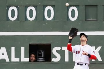 La persona encargada del marcador del estadio de los Red Sox, observa como Josh Donaldson, de los Toronto Blue Jays, coge la bola. 