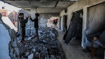 Los hijos de Mahmoud Al-Durra, de 32 años, de Gaza, desplazado a la ciudad de Rafah, en el sur de la Franja, tras las incursiones israelíes que destruyeron su casa y donde falleció su mujer, jugando en las ruinas el 31 de enero.