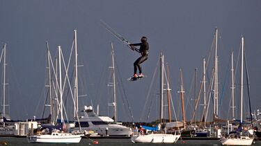 Ausralia acaba de entrar en la estación invernal y un frente frío golpea partes del sur del país. Sin embargo, eso no es impedimento para realizar determinados deportes acuáticos, más propios del verano. En la imagen, un hombre practica kitesurf junto a varias embarcaciones en un nublado y tormentoso día en la bahía de Port Phillip, en Melbourne.