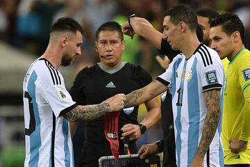 Lionel Messi gives the captain's armband to Di María during Argentina's game against Brazil.