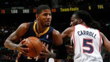 Paul George (24), de los Pacers, intenta zafarse de DeMarre Carroll (5).