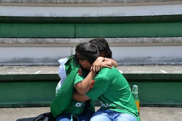 Fans console each other outside Chapecoense's stadium following the disaster.