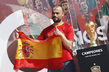 Seguidores de la selección española de fútbol se fotografían junto al trofeo. 