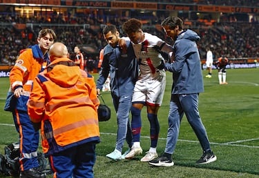 Desire Doue sale del campo entre lágrimas y ayudado para ser trasladado en camilla.