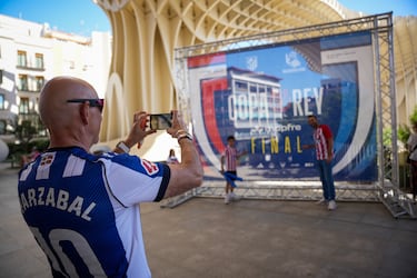 Un aficionado de la Real Sociedad le hace una foto a dos aficionados del Atlético de Madrid en Sevilla.