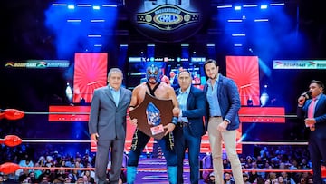 Momento en que Hechicero festeja con el trofeo de la Leyenda Azul en el centro del ring.