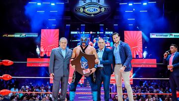 Momento en que Hechicero festeja con el trofeo de la Leyenda Azul en el centro del ring.