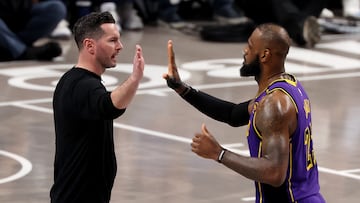 Head coach JJ Redick of the Los Angeles Lakers high fives LeBron James #23 during the third quarter against the Dallas Mavericks at American Airlines Center on April 09, 2025 in Dallas, Texas.