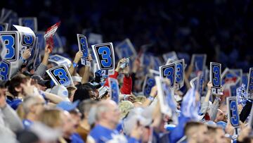 Detroit Lions fans hold up cards with the number three on them.