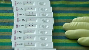 A Health worker wearing personal protective equipment (PPE) checks rapid antigen tests for  COVID-19 coronavirus after collecting swab samples from people, in Kolkata on August 8, 2020. - India&#039;s official coronavirus case tally passed two million on 