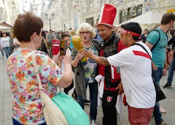 MOSCOW, RUSSIA - JUNE13 : Fans of Peru meet Russian ladies doing their shopping and show them a replica of the FIFA World Cup on June 13, 2018 in Moscow, Russia. (Photo by Matthew Ashton - AMA/Getty Images)