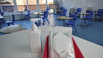 Mascarillas y gel desinfectante en la mesa del profesor de un aula del colegio Virgen de Europa en Boadilla del Monte