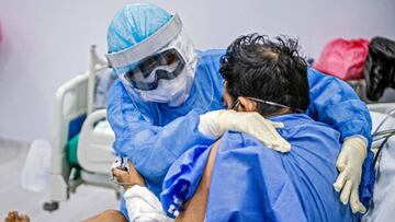 A nurse performs physical therapy on a COVID-19 patient at the Intensive Care Unit of the Alberto Sabogal Sologuren Hospital, in Lima, on July 02, 2020, amid the new coronavirus pandemic. (Photo by Ernesto BENAVIDES / AFP)