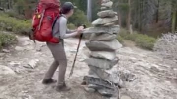 Senderista derribando una columna de piedras